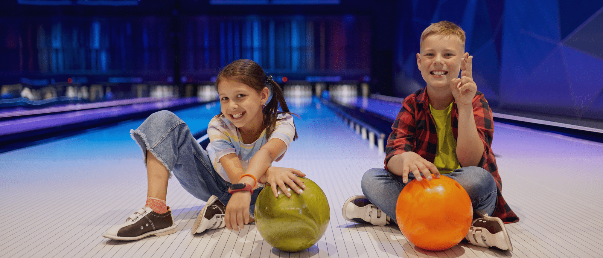 2 children posing with bowling balls at an alley. To support VAT relief campaign